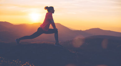 Silhouette of athletic girl doing stretching after a great jog in the mountains at sunset. Sport tight clothes.