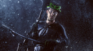 Mountainbiker carries his bike through the rain